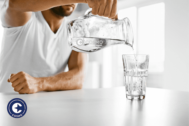 man pouring water into glass
