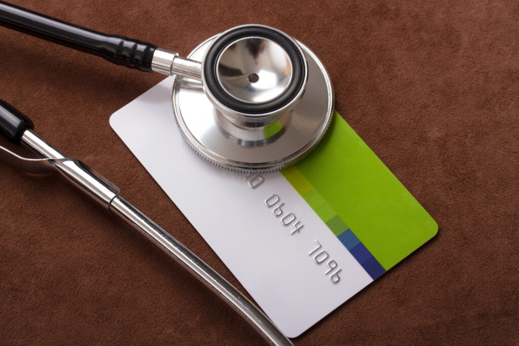 Stethoscope,On,A,Credit,Card,Concept,With,A,Brown,Background
