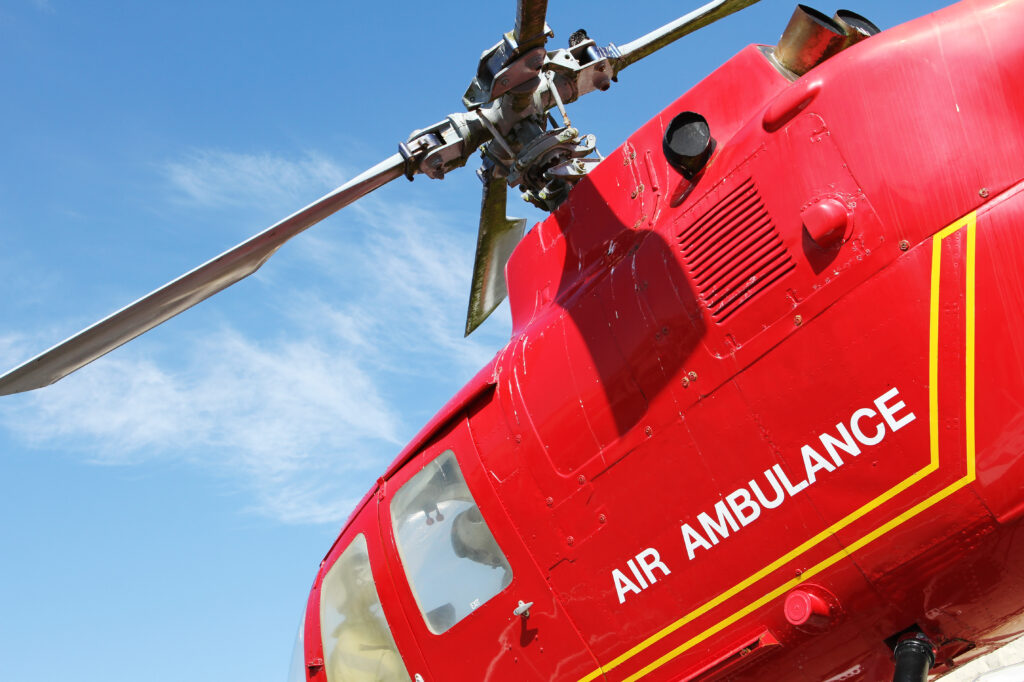 Red,Helicopter,Of,Air,Ambulance,Isolated,On,Blue,Sky,Background.