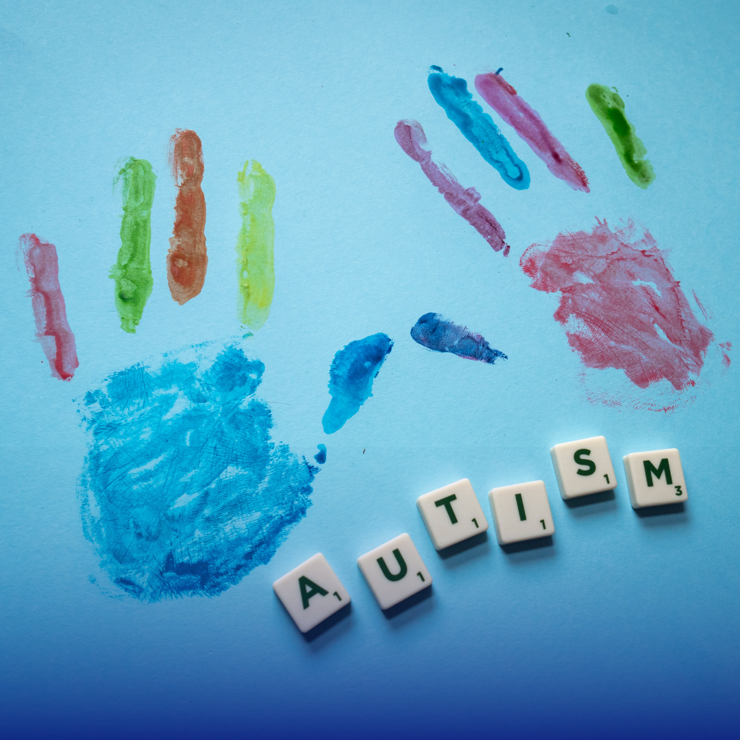 A blue handprint with colorful finger marks and the word "AUTISM" spelled out in Scrabble tiles.